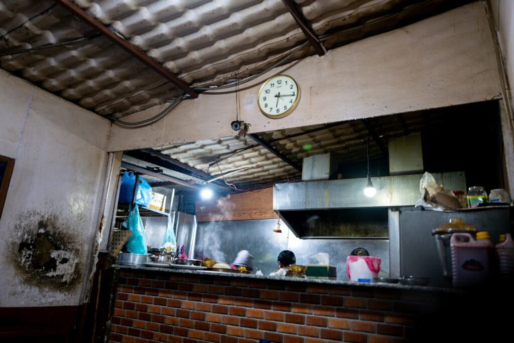 A dimly lit kitchen with a clock on the wall