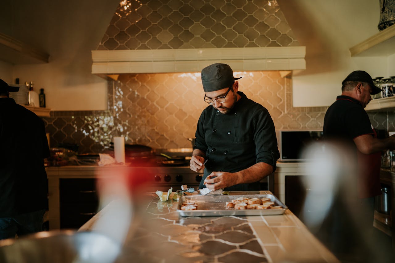 Chef in kitchen skillfully preparing gourmet dishes with expertise.