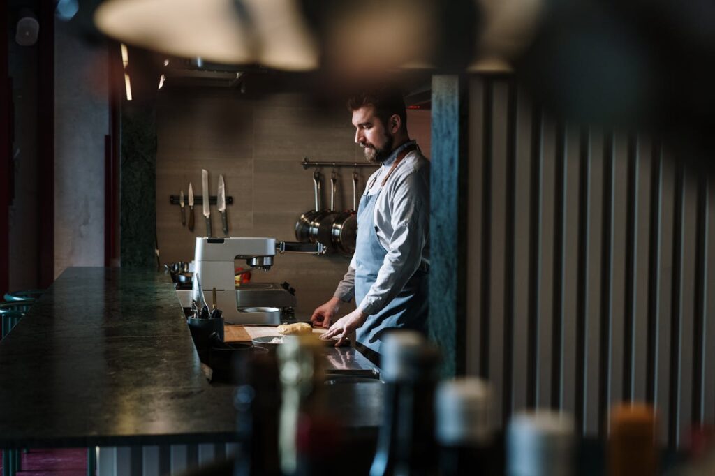 A skilled chef preparing ingredients in an industrial kitchen setting.